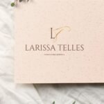 Logotipo de Larissa Telles com iniciais LT em tipografia manuscrita sobre fundo nude.