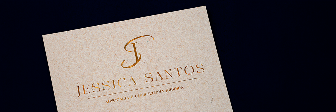 Logotipo dourado em papel de identidade visual jurídica, design elegante criado pela Jurinow.