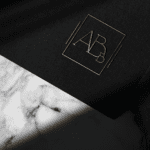 Logotipo dourado de escritório jurídico em fundo preto, design minimalista criado pela Jurinow.